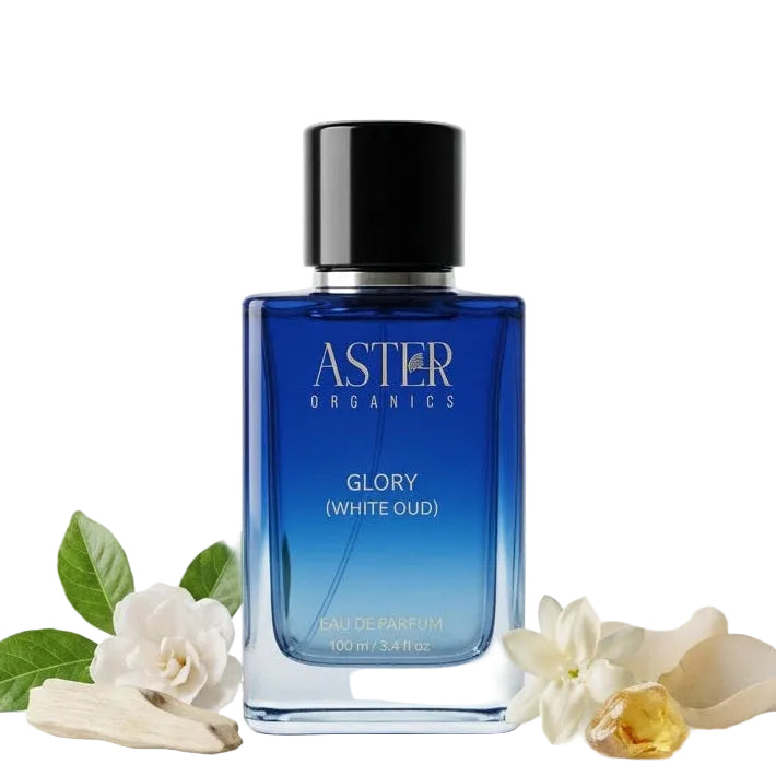 Blue bottle of Aster Organics Glory White Oud on a white background with flowers.